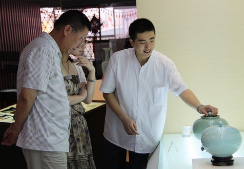 收藏爱好者仔细聆听讲解员讲述青瓷作品